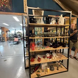 Metalen stellingkast met glazen items, servies, kannen en decoratieve artikelen