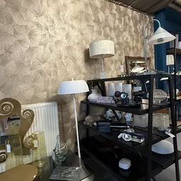 Zwarte open kast met diverse huishoudelijke items, lampen en decoratie