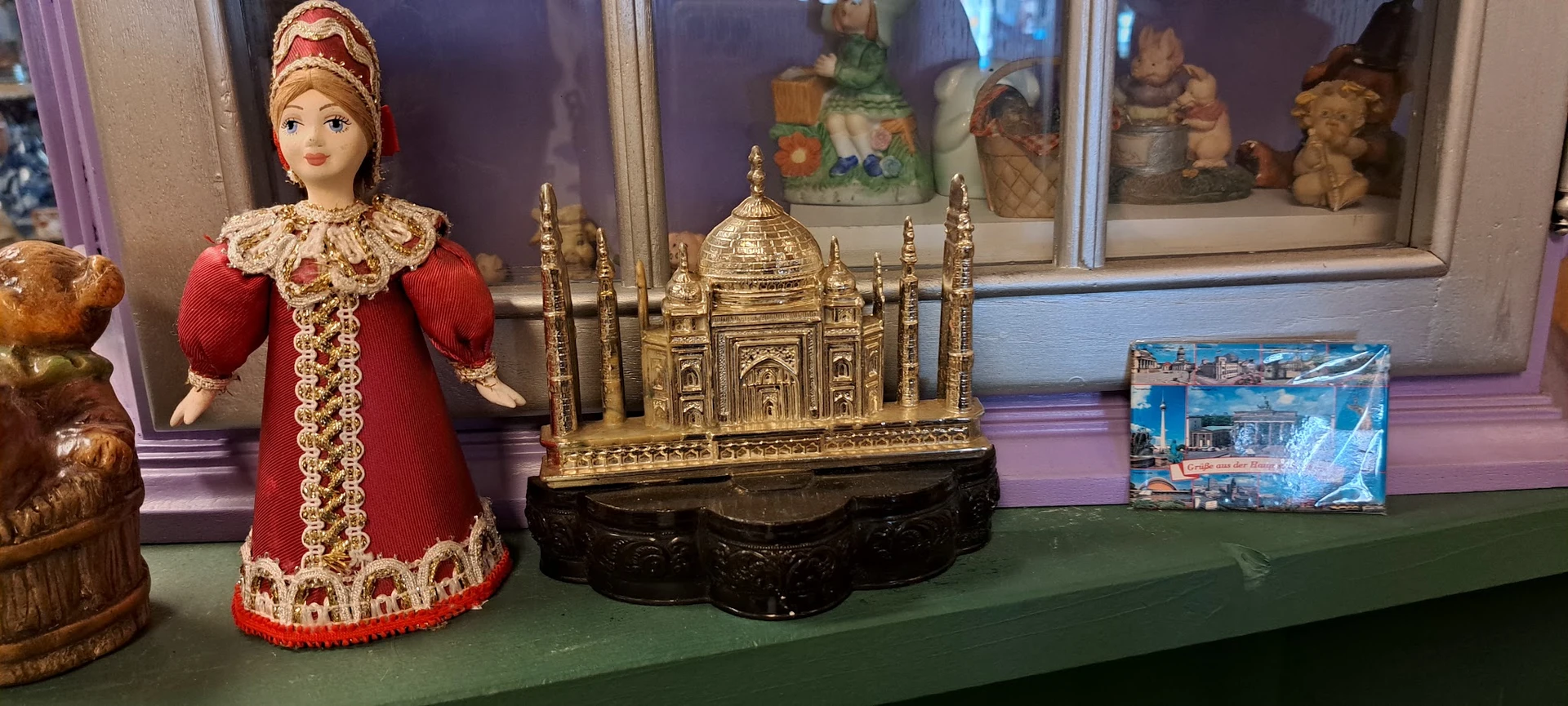 Gouden miniatuurnachteming van de Taj Mahal met zwart voetje tussen andere decoratieve artikelen in de winkel