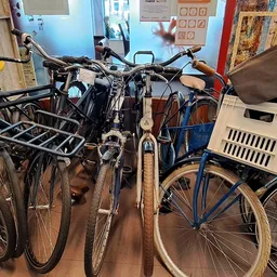 Verzameling tweedehands fietsen en fietsonderdelen uitgestald in de winkel