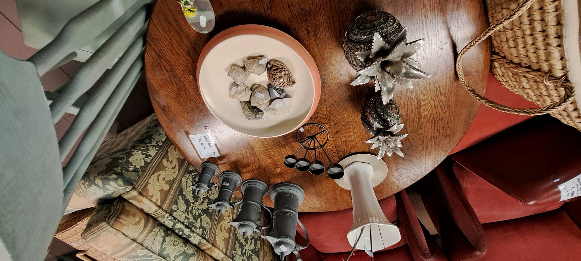 Houten tafel met vintage servies, binoculars, decoratieve items en textiel