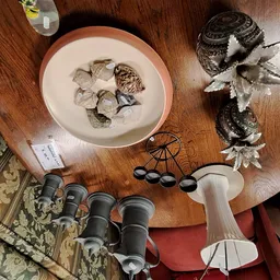 Houten tafel met vintage servies, binoculars, decoratieve items en textiel