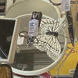 Tweedehands kappersmachine en decoratieve vlinderdecoratie in vitrine