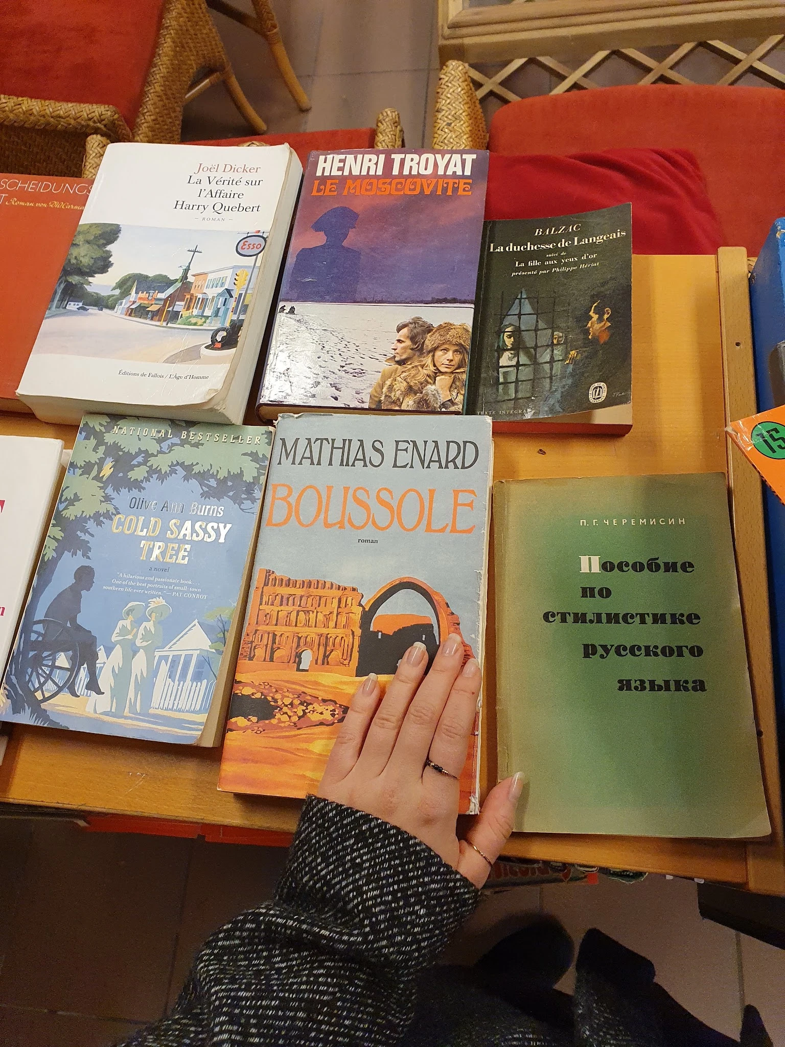 Tweedehands boeken uitgestald op tafel, waaronder werken van Mathias Enard en Russische taalhandboeken