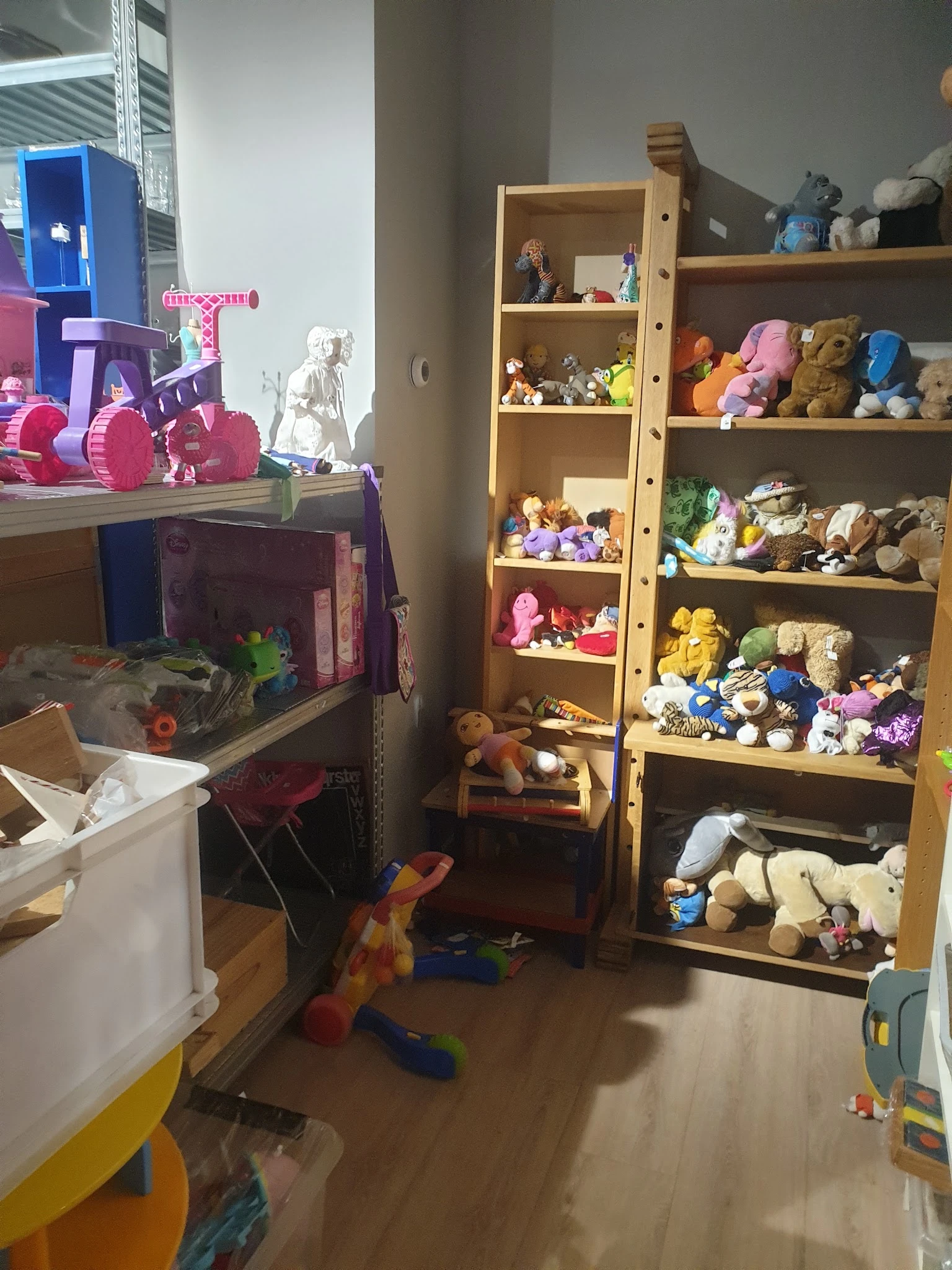 Houten boekenkast vol met knuffels, speelgoed en verzamelobjecten in verschillende kleuren