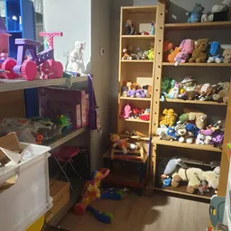 Houten boekenkast vol met knuffels, speelgoed en verzamelobjecten in verschillende kleuren