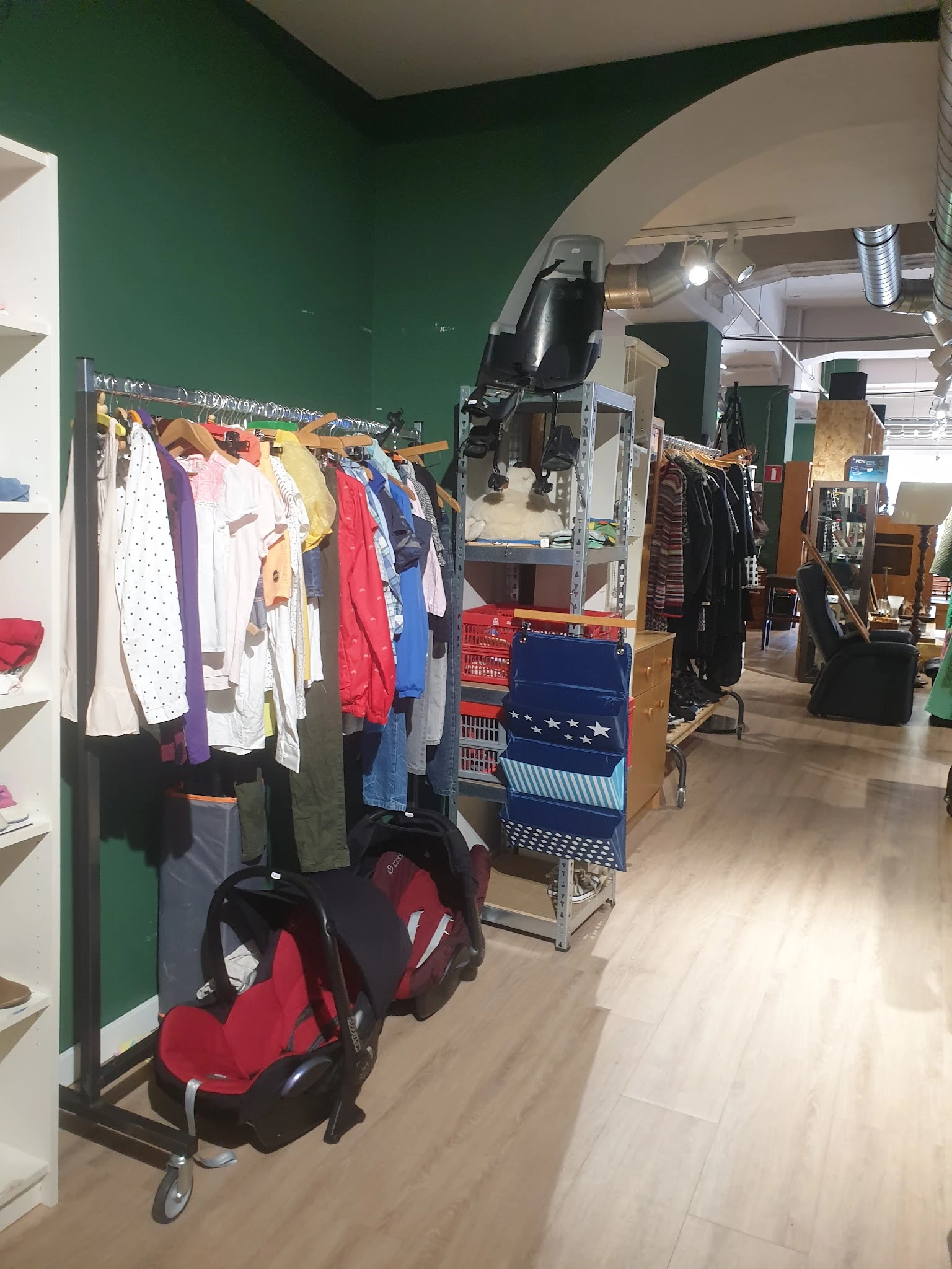 Rekken met tweedehands kleding in verschillende kleuren en stijlen