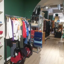 Rekken met tweedehands kleding in verschillende kleuren en stijlen
