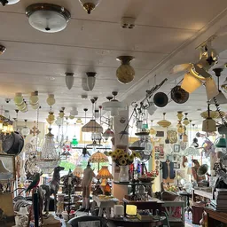 Winkelinterieur met talrijke hangende lampen en verlichtingsartikelen aan plafond en wanden