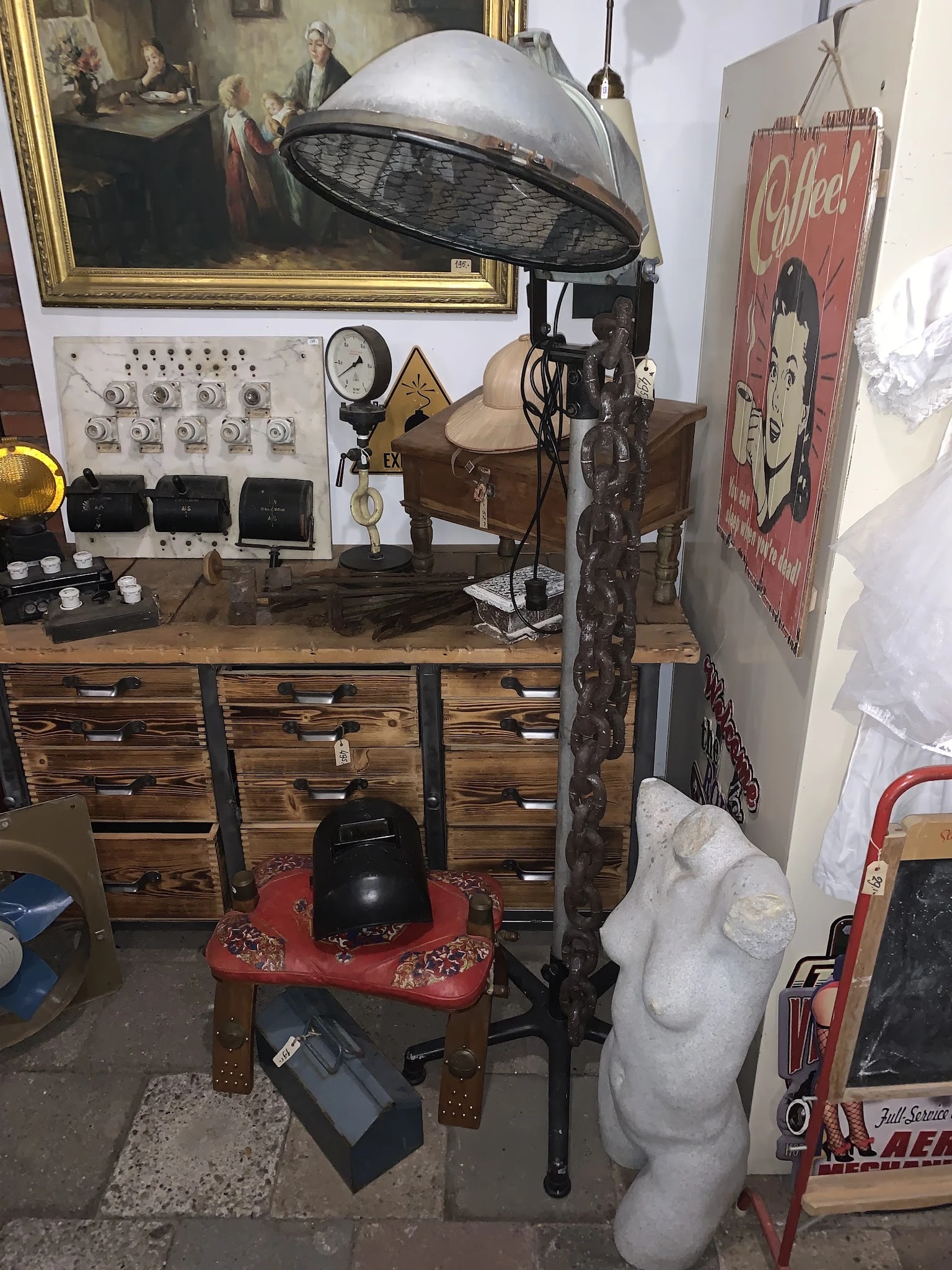 Houten ladekast met diverse decoratieve items, lampen, elektrische installaties en beeldhouwwerk op tafel