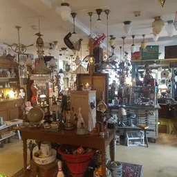 Winkelvloer met hangende verlichting, kasten, tafels en diverse tweedehands spullen
