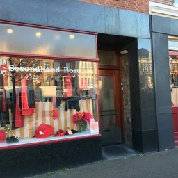 Winkelruit met rode en beige kleuren en etalage met mannequins in tweedehandskleding
