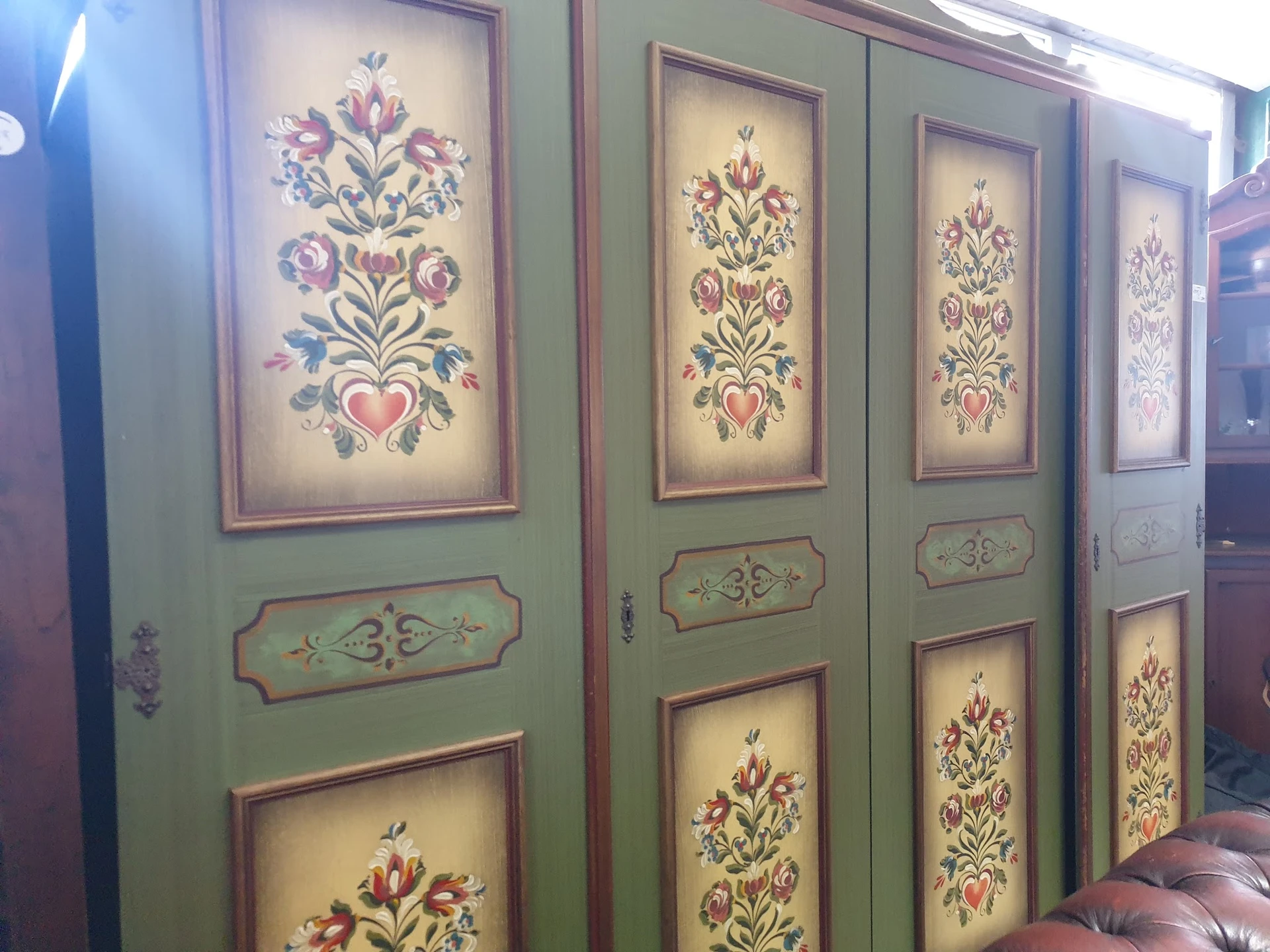 Vier groene kastdeuren met decoratieve schilderingen van bloemmotieven in verschillende kleuren