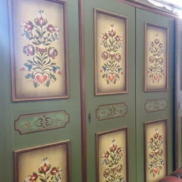 Vier groene kastdeuren met decoratieve schilderingen van bloemmotieven in verschillende kleuren