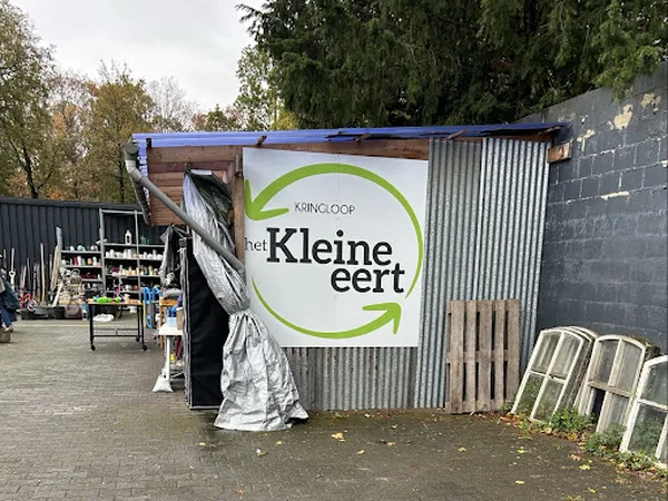Voorkant van kringloopwinkel met blauwe afdak en wit bord met groene Kringloop Kleine Eert logo