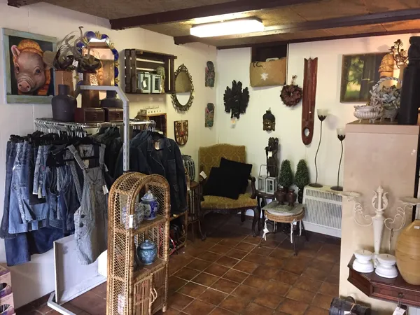Winkelvloer met kledingrekken, decoratiestukken, meubels en wanddecoraties in een secondhandwinkel