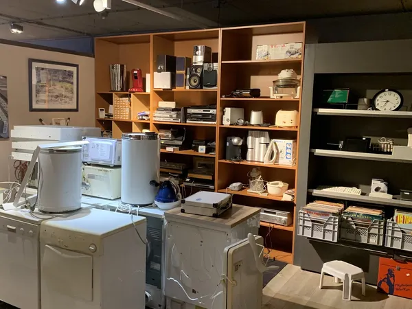 Winkelinterieur met houten kasten, wasmachines, drogers en diverse huishoudelijke artikelen op stellingen