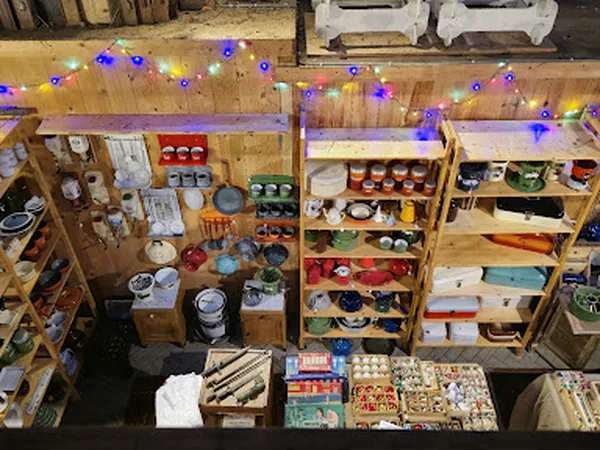 Winkelvloer met houten stellingen vol boxen, voorraden en spullen, versierd met gekleurde lampjes