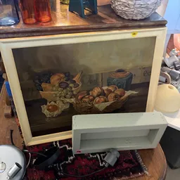 Schilderij met stilleven van fruit en groenten in houten lijst, naast witte plankje