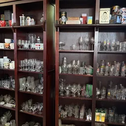 Glazen kasten met grote collectie glazen en drinkglazen in verschillende stijlen en maten