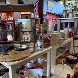 Uitgestalde huishoudelijke artikelen en serviesgoed op tafels in de winkel