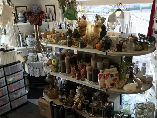 Uitgestalde decoratie-artikelen, kaarsen, beelden en accessoires op houten kasten in de winkel