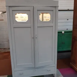 Twee grijze deuren met geslepen glaspanelen en spiegels erboven