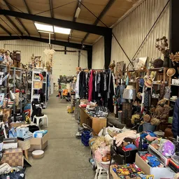 Overzicht van de winkelvloer met kleding aan rekken, uitgezochte spullen en diverse tweedehands artikelen