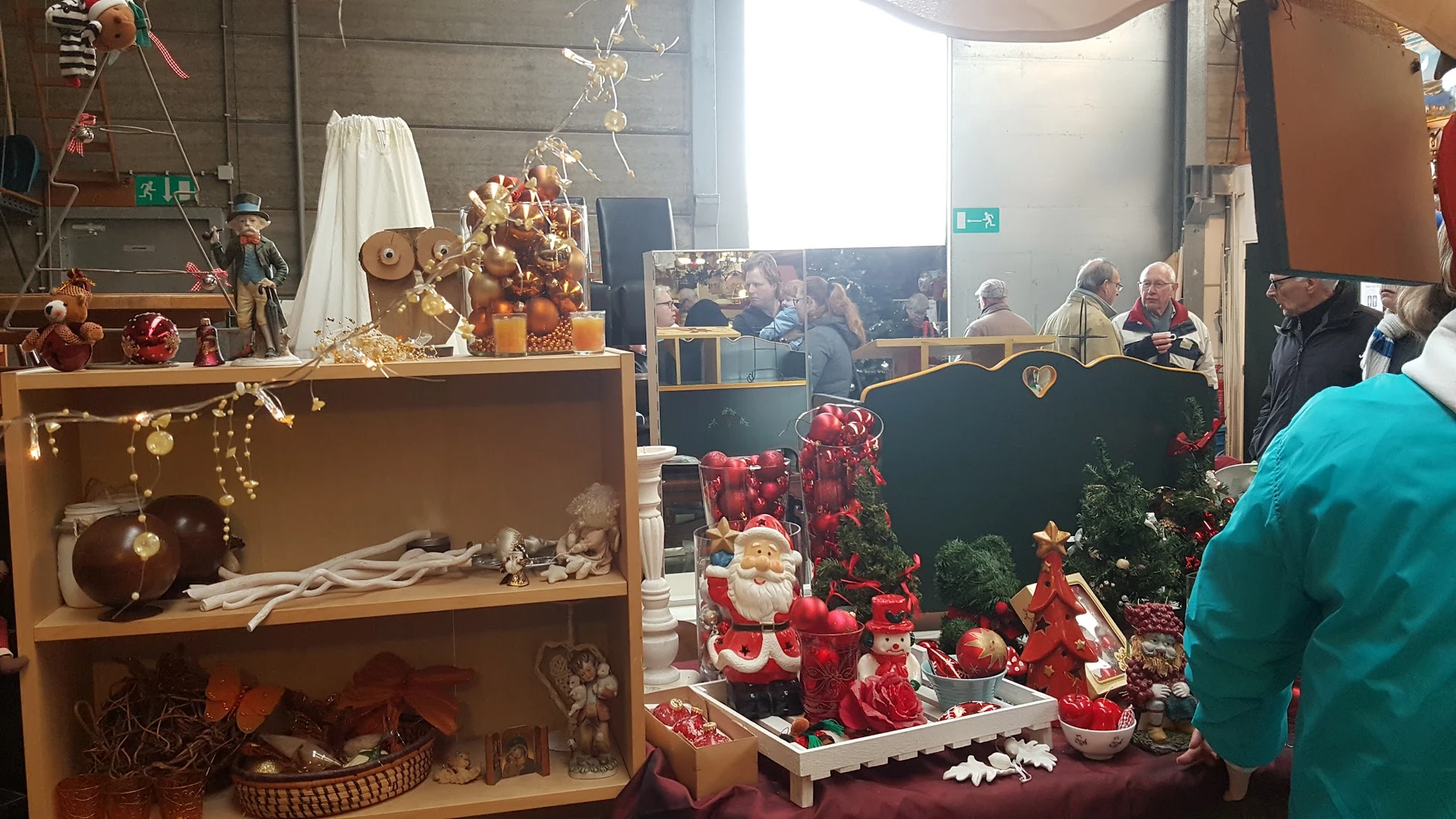 Kerstdecoratie en seizoensartikelen uitgestald in de winkel, met rode kerstballen, kaarsen en decoratieve items