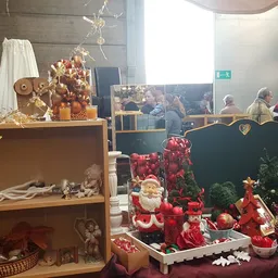 Kerstdecoratie en seizoensartikelen uitgestald in de winkel, met rode kerstballen, kaarsen en decoratieve items