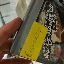 Geel prijskaartje met handgeschreven tekst op winkelrek
