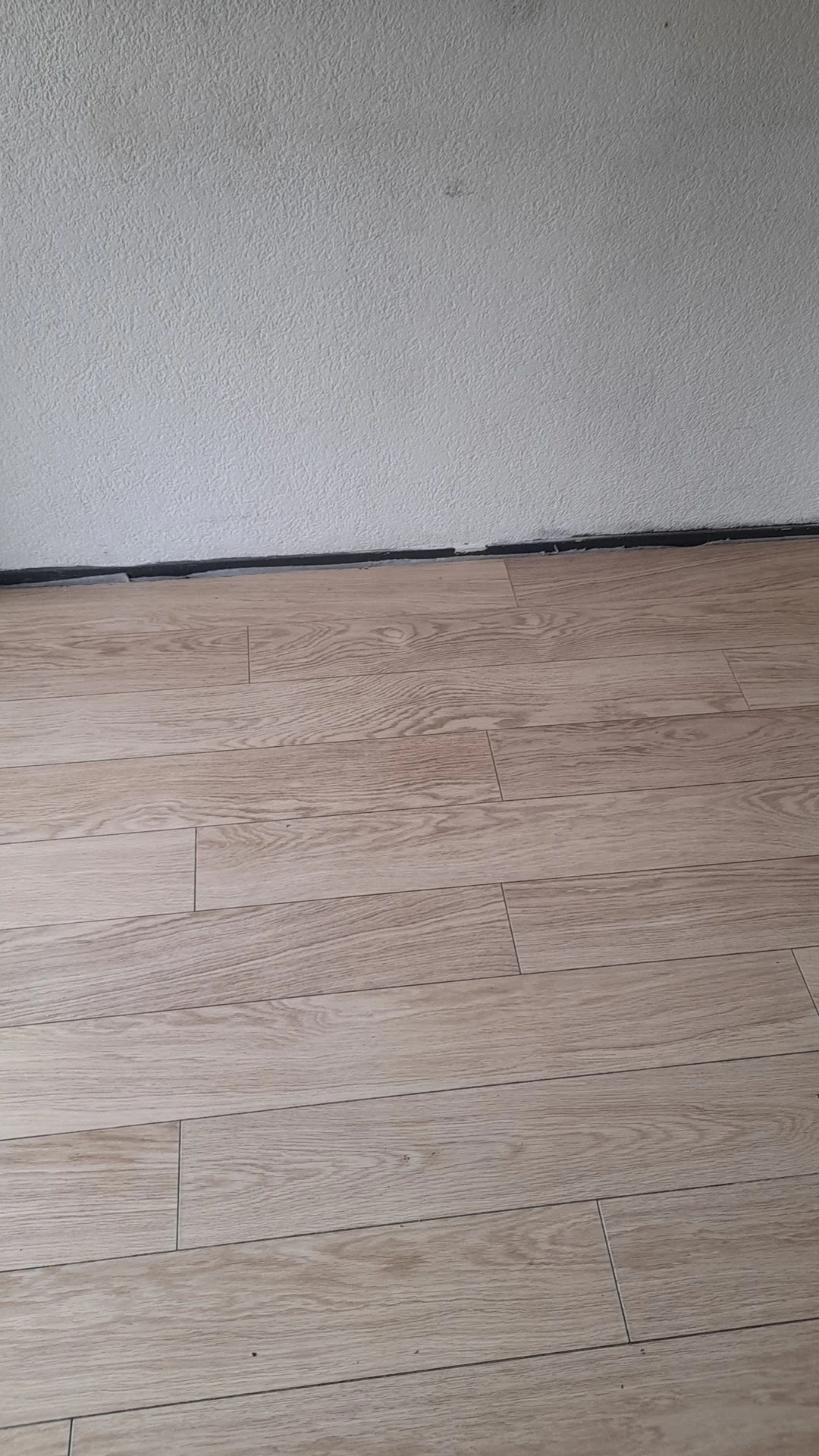Laminaat houten vloer in een winkelruimte met grijze muur