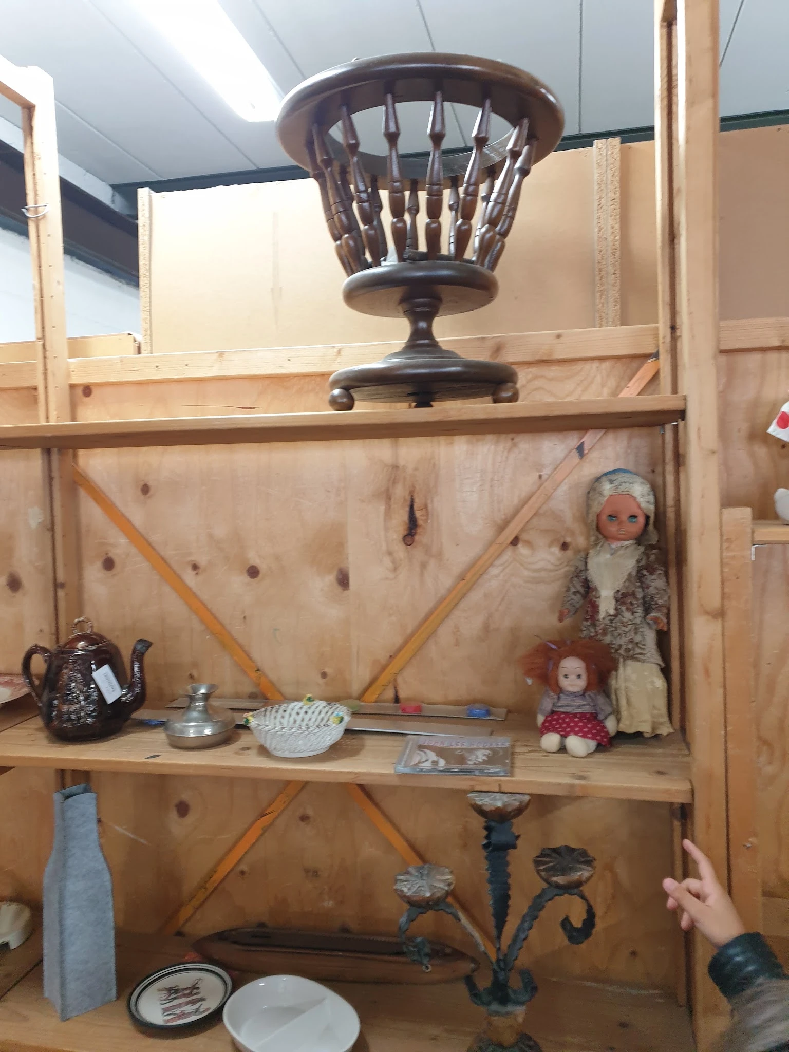 Houten stellingkast met vintage huishoudartikelen, decoraties en poppenhuispoppen