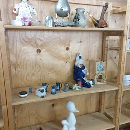 Houten kastje met diverse gebruiksartikelen en decoratiestukken op twee niveaus