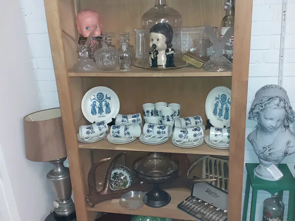Houten vitrinekast met serviesgoed, glazen en decoratieve items uitgestald op meerdere niveaus
