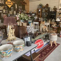 Winkelvloer met diverse tweedehands spullen: servies, beeldjes, lampen, meubels en decoratie