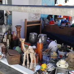 Verzameling tweedehands huishoudartikelen en decoratiestukken op een toonbank
