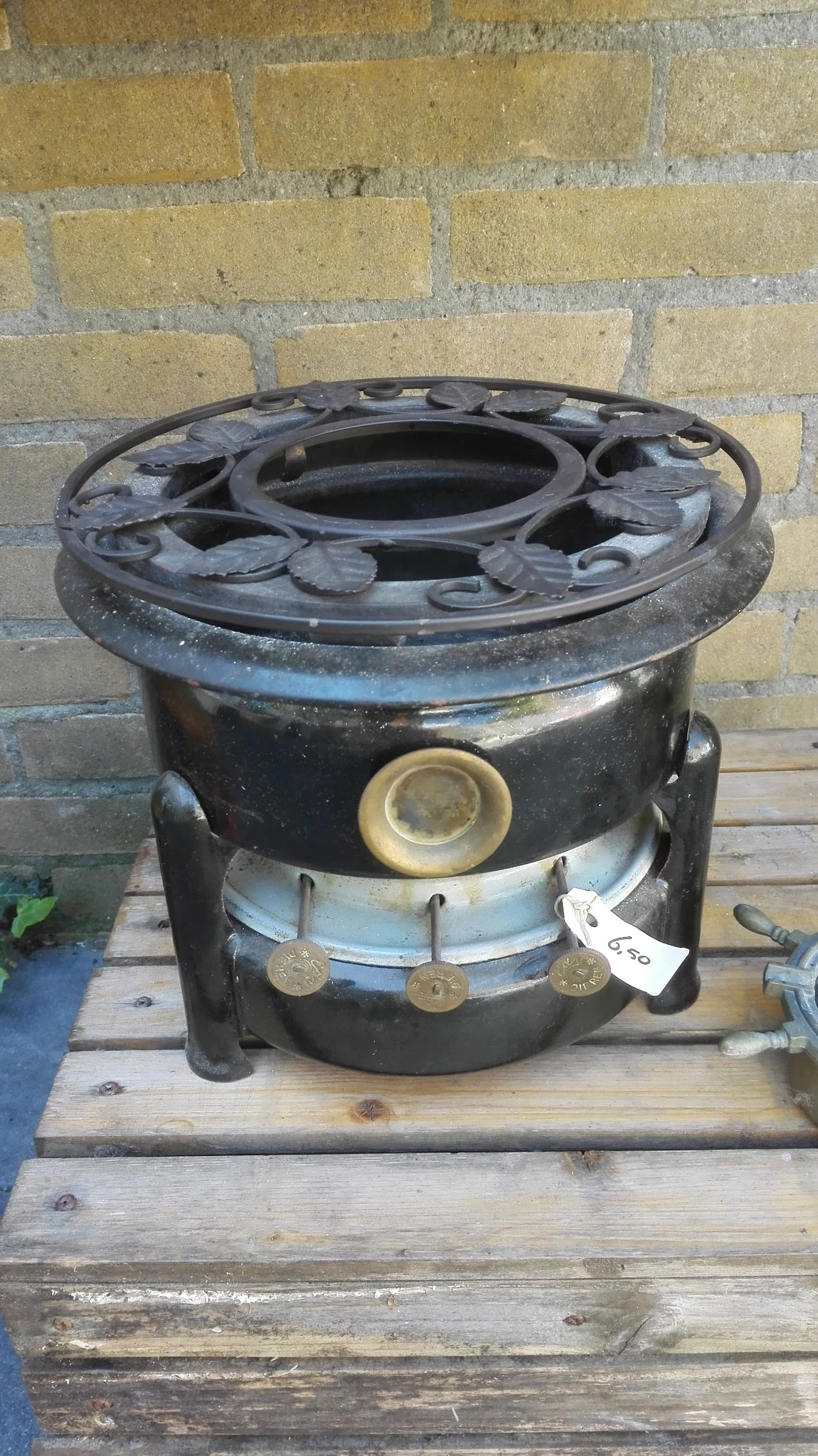 Zwarte vintage kachel of fornuis met messing onderdelen en regelknoppen