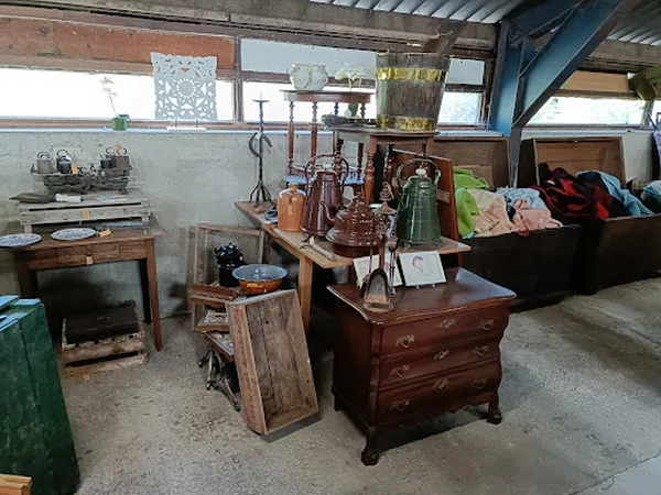 Winkelvloer met vintage meubels, dozen met kleding en diverse spullen uitgestald