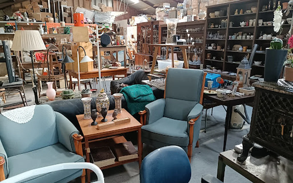 Winkelvloer met meubels uitgestald: blauwe stoelen, houten tafeltjes, lampen, kasten en diverse huishoudspullen
