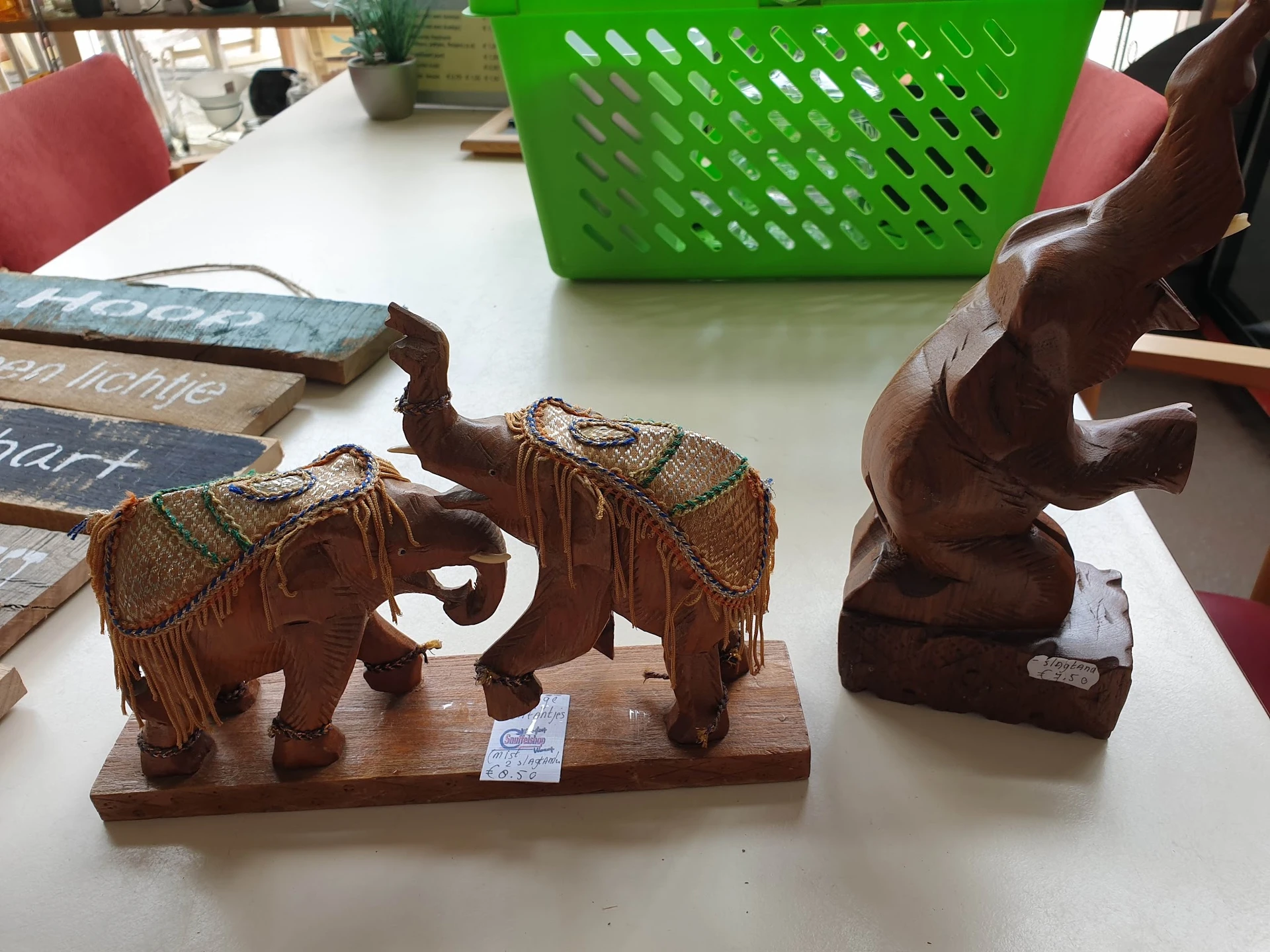 Houten olifanten beeldjes met decoratieve stoffen doeken op een tafel