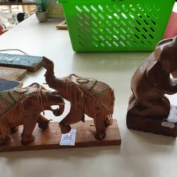 Houten olifanten beeldjes met decoratieve stoffen doeken op een tafel