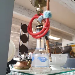 Decoratieve waterpijp met rode slang en blauwe pluimen op glazen bol