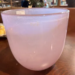 Glas met roze drankje op houten tafel in kringloopwinkel