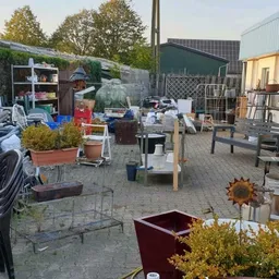 Buitenterrein van kringloopwinkel met uiteenlopende tweedehands spullen, meubilair en tuinartikelen