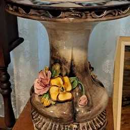 Close-up van een decoratieve vaas met geschilderde bloemen in roze en geel
