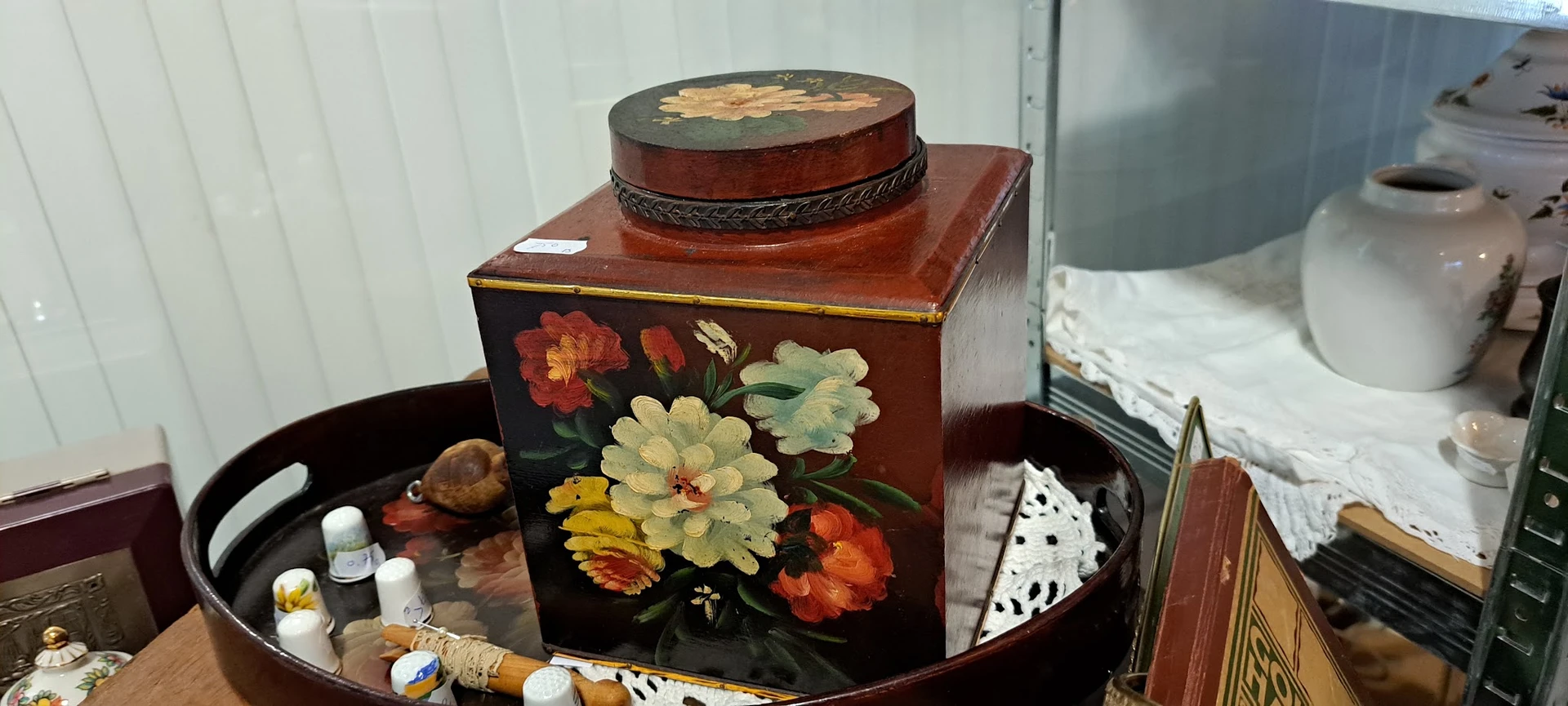 Houten juwelenkistje met bloemendecoratief werk en ronde sieradendoos erop