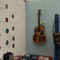 Akoestische gitaar met houten kastje opgehangen aan muur, versierd met plantjes