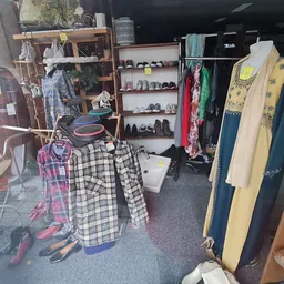 Kringloopwinkel met kledingrekken, schoenen en diverse tweedehands spullen