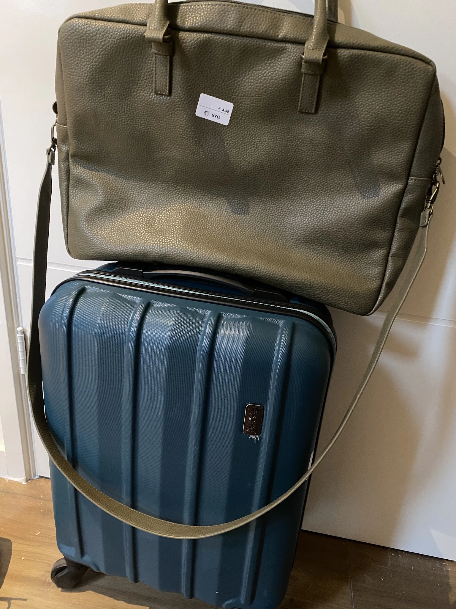 Tweedehands bagageset: groene schoudertas en blauwe koffer met ribbelpatroon.